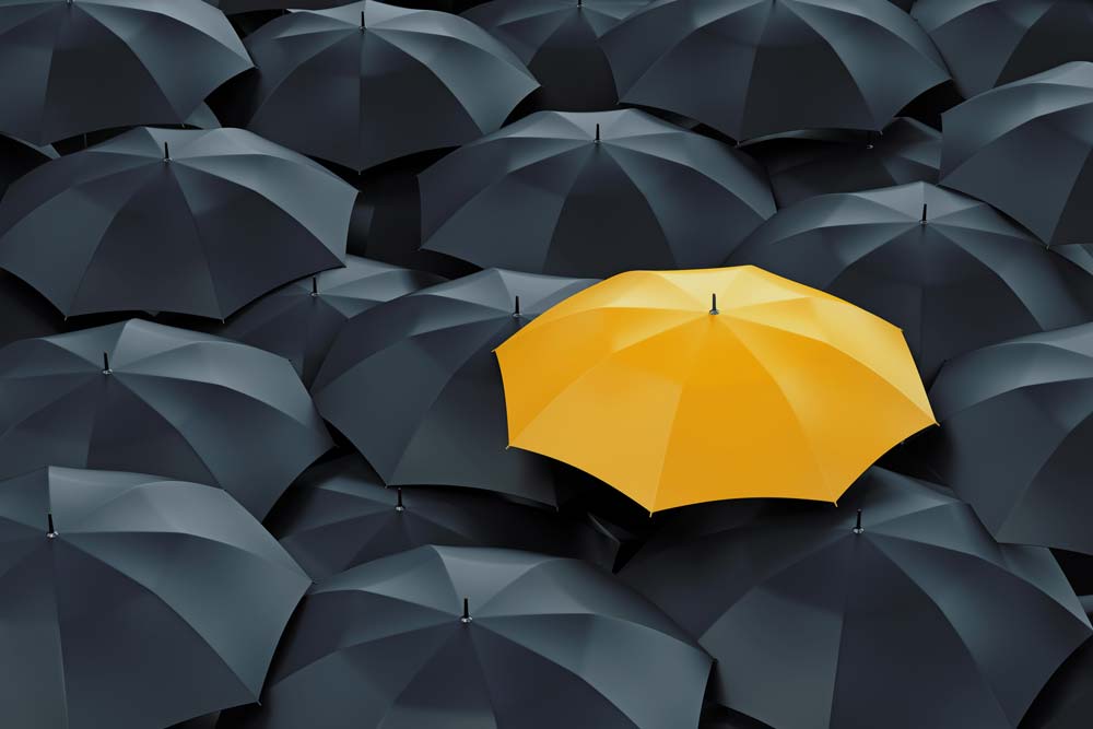 Flera svarta paraplyer med ett gult i mitten